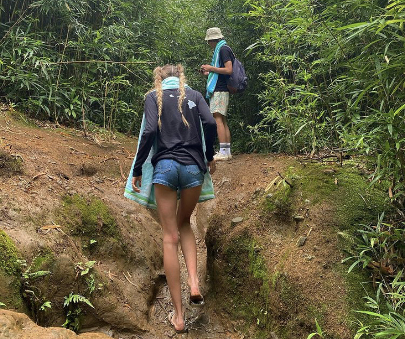 Woman hiking in an uphill section with a man in the distance
