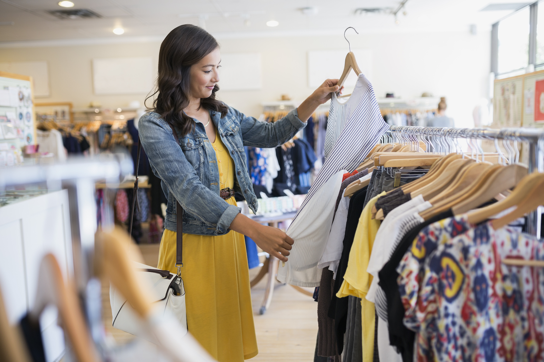 Woman holding up a piece of clothing while clothes shopping