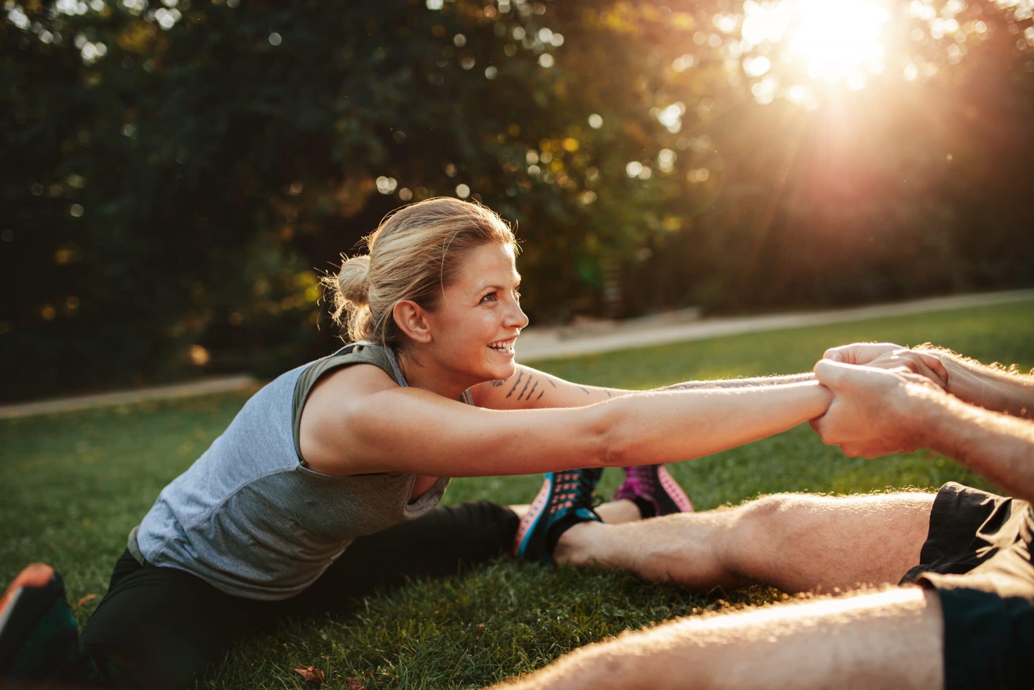 Man stretching a woman by pulling her arms.