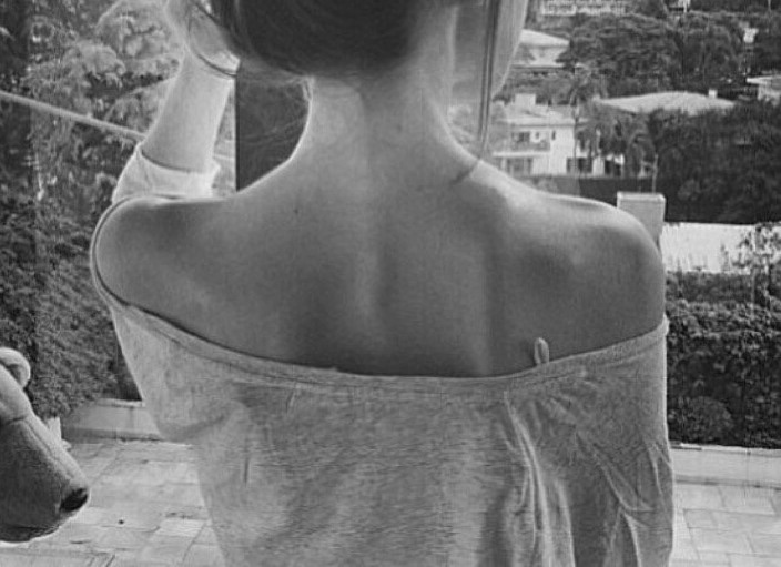 Back view of female standing who has contoured trapezious.
