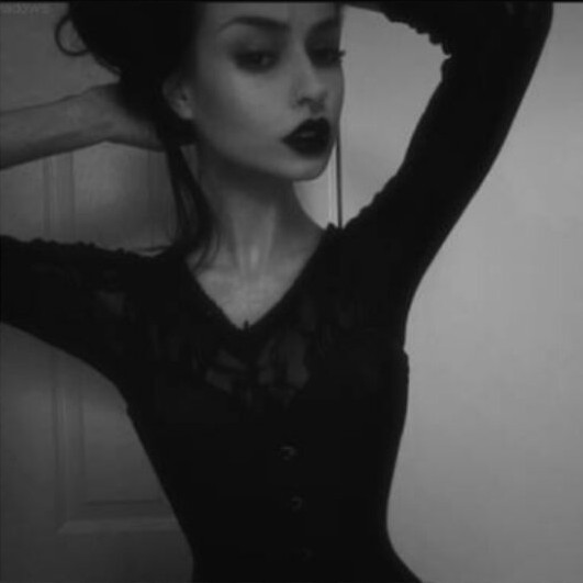 Front view of woman touching her hair with both hands.