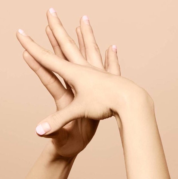 Womans hands being touched together only at the fingertips.
