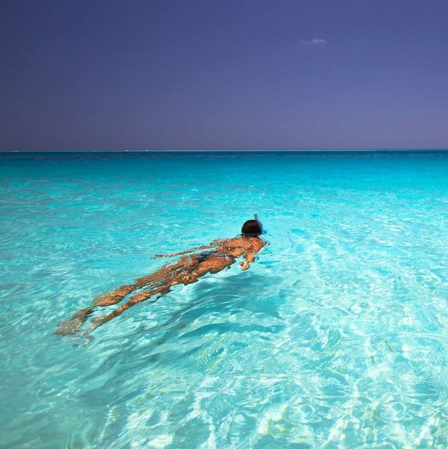 Woman swimming in the ocean near sunset