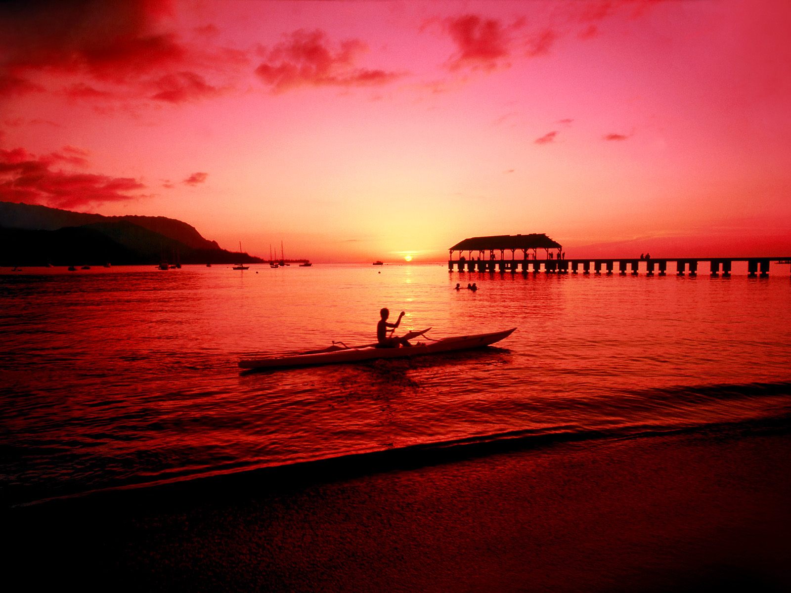 Person rowing a boat against a bright red sky during sunset
