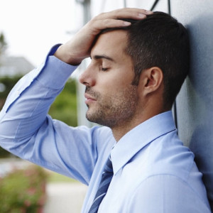 Man sitting down and grabbing his head
