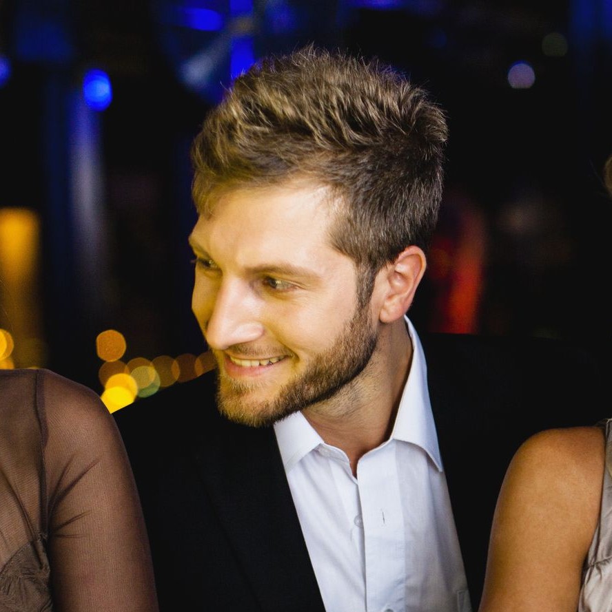 Man sitting in a circle of people, with two women adjacent to him
