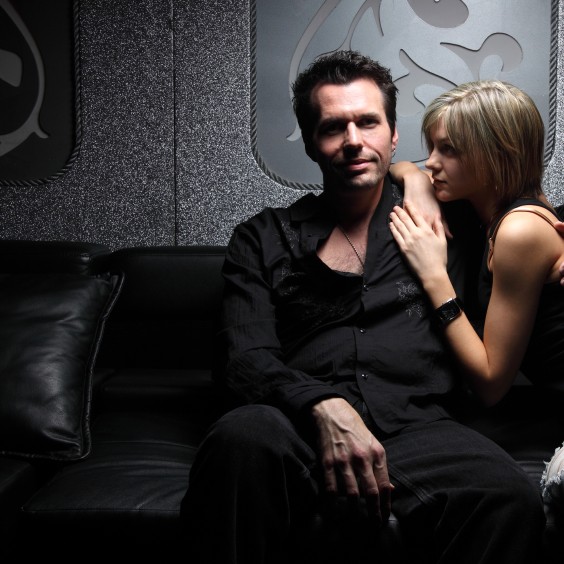 Man sitting on a couch with a woman curled up next to him