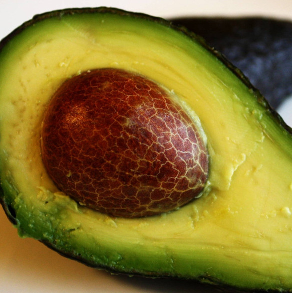 Avocado sliced in half with pit still inside