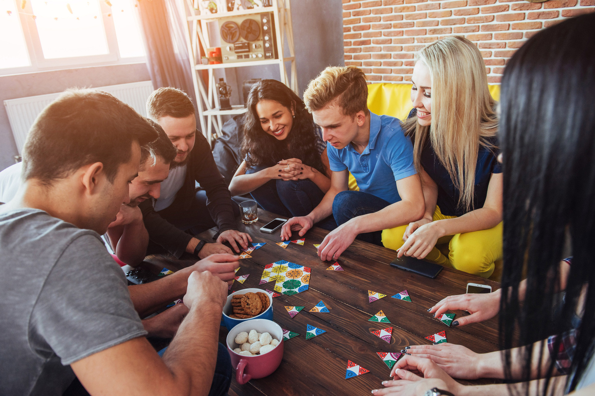 Group  of young people around a board game having fun